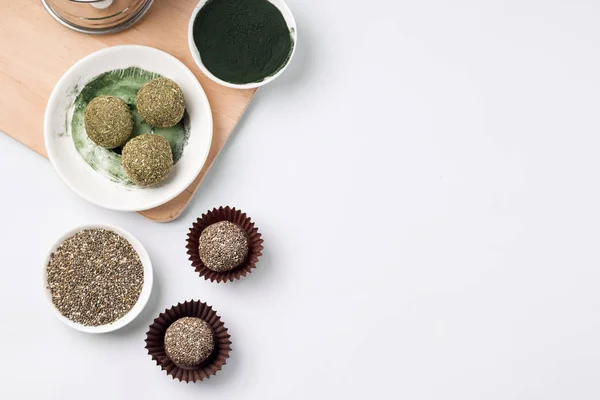 energy ball in dry mint and spirulina. Healthy sweets cooking. Next to a bowl of chia seeds