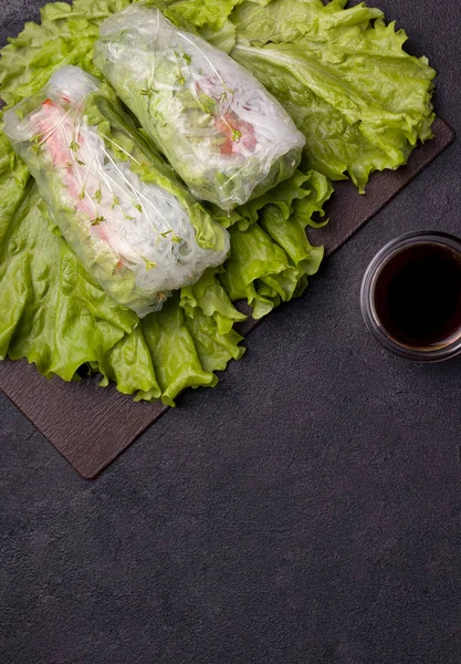 Jarní závitky na zeleném talíři vedle šedé omáčky na černém pozadí. mají kopírovací prostor. vegetariánské jídlo — Stock fotografie