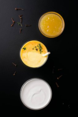 Lassi mangosu reçel ve siyah arkaplanda yoğurt yanında içer. en üstteki görünümde