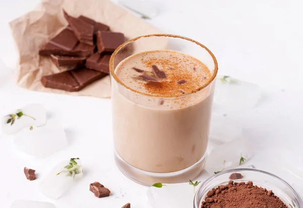 Lassi Schokoladengetränk neben Eiswürfeln, Schokolade und Kakao auf weißem Hintergrund — Stockfoto