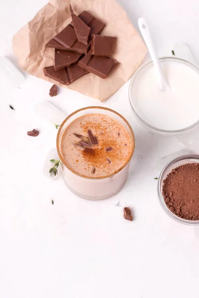 O chocolate Lassi é uma bebida fria tradicional indiana ao lado de cacau, iogurte e pedaços de chocolate. close-up — Fotografia de Stock