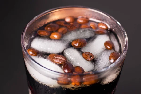 Σόδα καφέ με πάγο σε μαύρο φόντο σε ποτήρι — Φωτογραφία Αρχείου