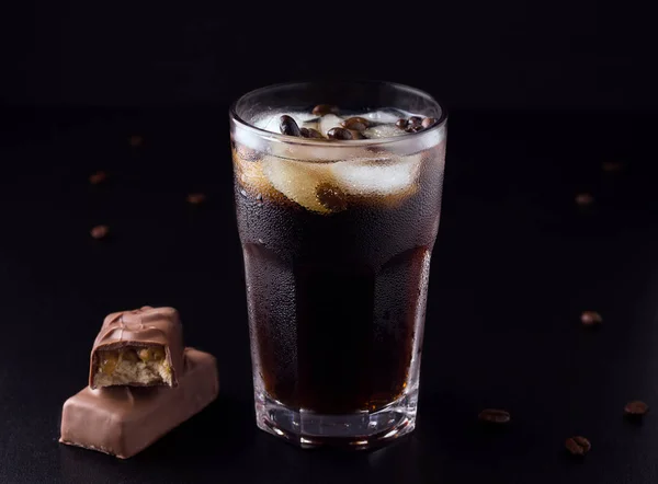 Παγωμένο καφέ σε μαύρο φόντο δίπλα σε κόκκους καφέ με σοκολάτα — Φωτογραφία Αρχείου