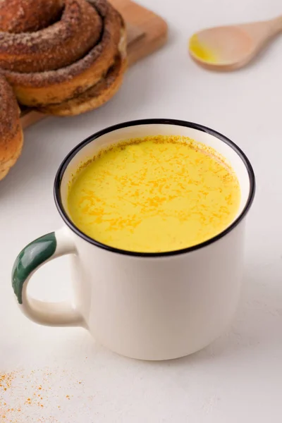 Minuman sehat susu emas di samping roti gulung sarapan. foto vertikal — Stok Foto