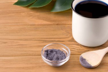 Mavi kibrit çayı kuru ve ahşap bir arka planda kupada hazır. Köy kavramı. Kopyalama alanı var