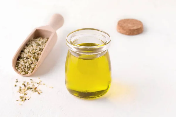 Hemp oil next to peeled hemp seeds on a white background. Have copy space — Stock Photo, Image