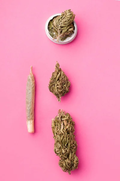 Konopí na růžovém pozadí vedle cigarety. vertikální fotografie marihuany — Stock fotografie