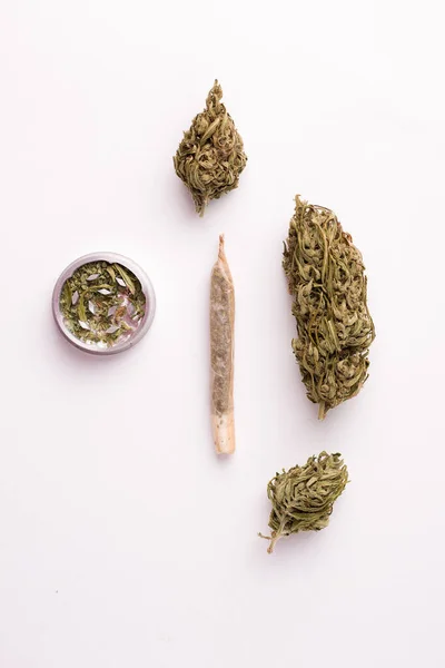 Zweige von Marihuana auf weißem Hintergrund in einem hohen Winkel neben einer Hanfzigarette — Stockfoto