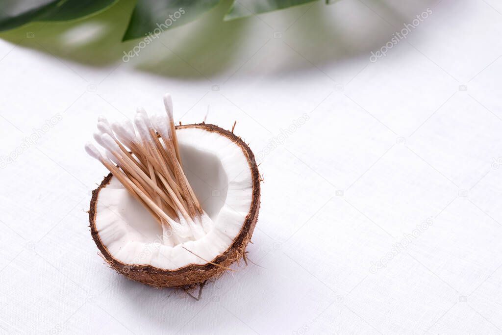 environmentally friendly ear sticks in coconut on a white background with copy space. zero waste concept