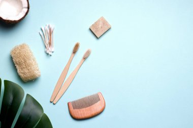 eco bath accessories such as a toothbrush, comb and ear sticks made of wood and a loofah washcloth. blue background. copy space.