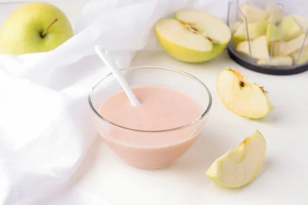 Hausgemachte Zubereitung von Babypüree. auf weißem Hintergrund eine Schüssel mit Kartoffelbrei, daneben Äpfel in Scheiben geschnitten — Stockfoto