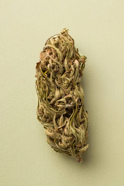 Dried marijuana on a green background close-up. vertical photo — Stock Photo, Image