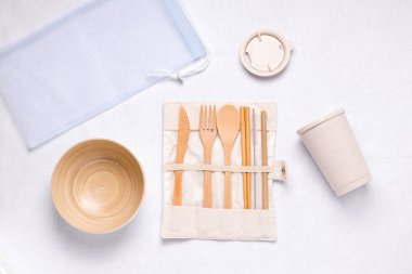 Çevre dostu mutfak aletleri beyaz arka planda ahşap, bambu ve metal pipetten yapılmıştır.