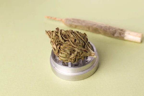 Marihuana neben einer Zigarette auf grünem Grund. Horizontales Foto — Stockfoto