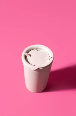 Pembe arka planda tekrar kullanılabilir kahve fincanı. Boşluğu kopyala