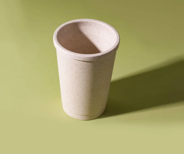 reusable coffee cup on a green background. minimalism