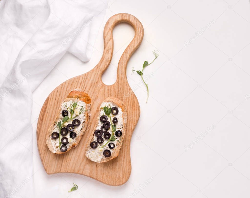 Bruschetta traditional dish, vegetarian sandwich with olives, cheese and micro greens on a white background. copy space