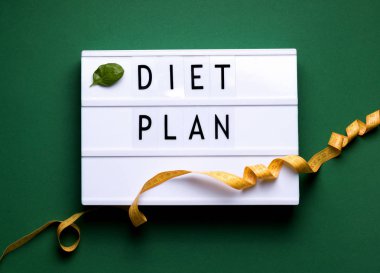 Yeşil zemin üzerinde diyet planı metni ve santimetre olan ışık kutusu