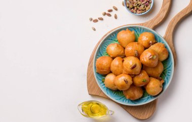 Lokma yağsız ürünlerden arap tatlısı. Beyaz arka planda bir tabakta. Boşluğu kopyala