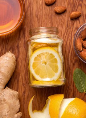 Gıda konsepti bağışıklık ve virüs koruması için kullanışlı. Ballı, zencefilli, nane şekerli ve bademli bir limon, ahşap bir masada yakın plan. Kırsal