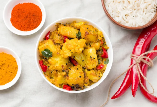 Gobi aloo Hint vejetaryen sebze yemeği kasenin içinde, malzemelerin yanında.
