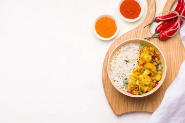 Ahşap doğrama tahtasının üzerinde Aloo gobi Hint vejetaryen sebze yemeği. Boşluğu kopyala