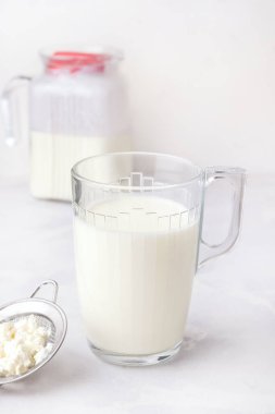 Beyaz arka planda mayalanmış süt kefir içer. Dikey fotoğraf. Sindirim için sağlıklı içecekler.