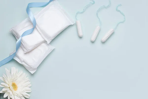 Regl döneminde korunma kavramı. Mavi arka planda iç çamaşırı ve tamponlar. Boşluğu kopyala