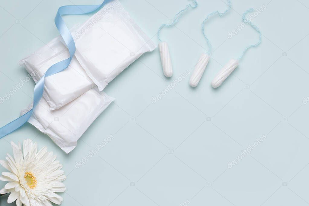 The concept of protection during menstruation. Panty liners and tampons on a blue background. Copy space