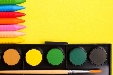 Çocukların yaratıcılık çizimi konsepti. Sarı arka planda boya ve boya. Uzayı kopyala Yukarıdan görüntüle