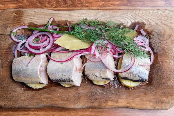 烤土豆和洋葱环鲱鱼的鱼片 免版税图库图片