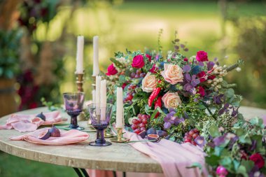 Düğün dekoru. Çiçekler, mumlar ve bardaklar.