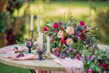 Düğün dekoru. Çiçekler, mumlar ve bardaklar.