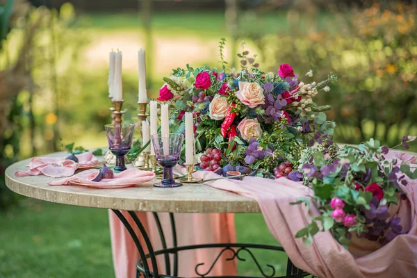 Düğün dekoru. Çiçekler, mumlar ve bardaklar.