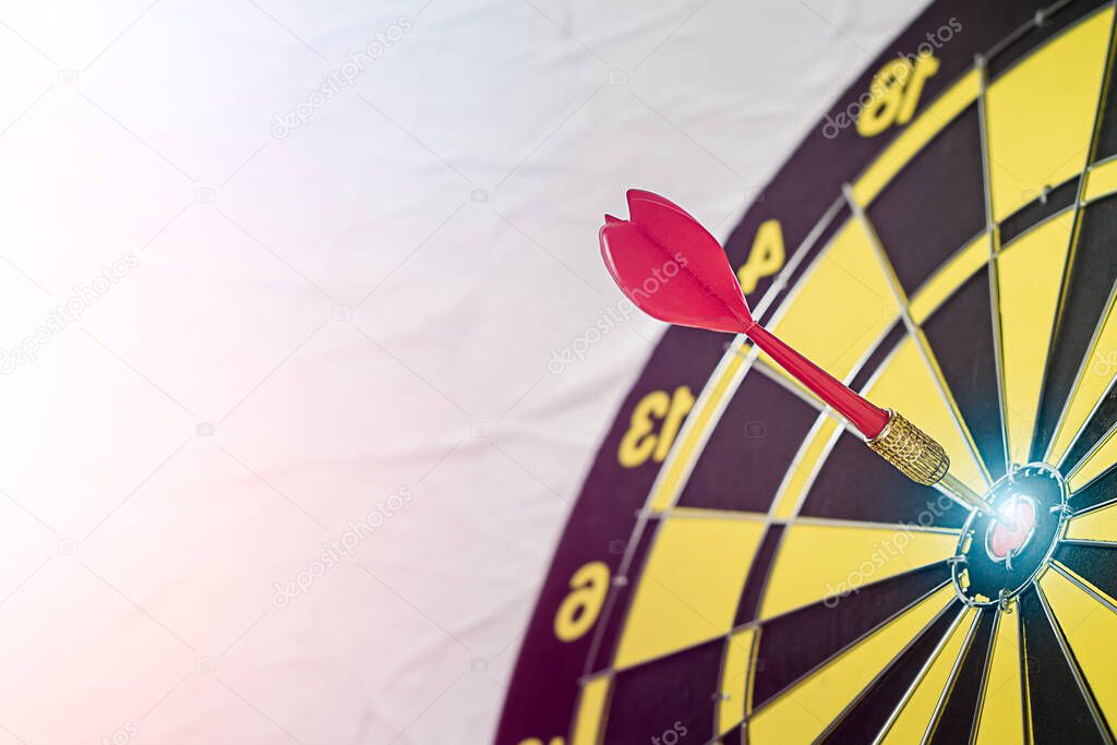 Background with symbol concept of business success achievement focus with red dart game aim and hit center target spot on dartboard for a professional winning