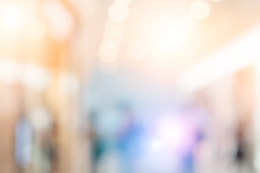Lüks moda alışveriş merkezlerinde arka planda bokeh ışığı ve mağazaların vitrinlerinde ve mağazaların kadın ve erkek müşterilerinin yürüme koridorlarında yürüdüğü modern modellerin görüntülerinde bulanıklık. 
