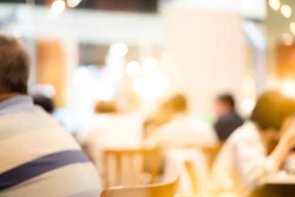 Blurred abstract backgrounds of crowded people sitting and eating food court canteens cafe cafeteria selling fresh food for employees during lunch in shopping mall