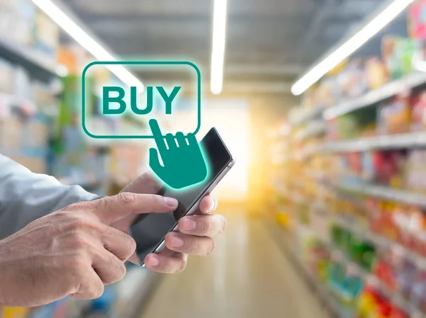 Blurred background of supermarket store with mobile online shopping to order groceries foods and goods delivery to home. Demand e-commerce of the service increase during coronavirus quarantine