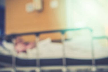 Görüntü hastanesinin arka planında yaşlı bir hasta yatıyor ve tekerlekli sandalye bekleme koridorunda bekliyor. Profesyonel hemşire ve doktorun desteğiyle hasta insanlar için kötü sağlık hizmeti 