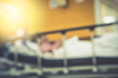 Görüntü hastanesinin arka planında yaşlı bir hasta yatıyor ve tekerlekli sandalye bekleme koridorunda bekliyor. Profesyonel hemşire ve doktorun desteğiyle hasta insanlar için kötü sağlık hizmeti 