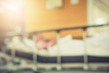Görüntü hastanesinin arka planında yaşlı bir hasta yatıyor ve tekerlekli sandalye bekleme koridorunda bekliyor. Profesyonel hemşire ve doktorun desteğiyle hasta insanlar için kötü sağlık hizmeti 