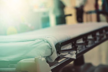 Soyut Görüntü hastanesi geçmişi, boş bir yatak ve bekleme odasındaki yaşlı bir hasta. Coronavirüs salgını sırasında uzman hemşire ve doktorun yetersiz sağlık desteği