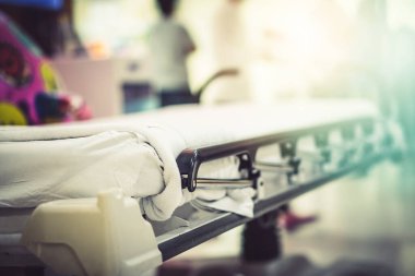 Soyut Görüntü hastanesi geçmişi, boş bir yatak ve bekleme odasındaki yaşlı bir hasta. Coronavirüs salgını sırasında uzman hemşire ve doktorun yetersiz sağlık desteği