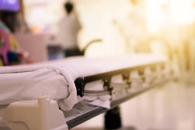 Soyut Görüntü hastanesi geçmişi, boş bir yatak ve bekleme odasındaki yaşlı bir hasta. Coronavirüs salgını sırasında uzman hemşire ve doktorun yetersiz sağlık desteği