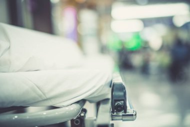 Soyut Görüntü hastanesi geçmişi, boş bir yatak ve bekleme odasındaki yaşlı bir hasta. Coronavirüs salgını sırasında uzman hemşire ve doktorun yetersiz sağlık desteği
