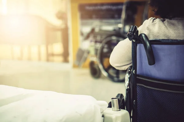 Blur hospital Background with old elder patient on bed and wheelchair waiting hallway ward. Poor healthcare treatment service for illness  sick people with support from professional nurse and doctor