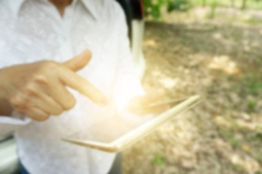 Yaşlı, yaşlı bir kadın bahçedeki doğal çiftlikte mutlu bir şekilde sohbet ediyor, okuyor, konuşuyor, arkadaşlarıyla mesajlaşıyor. Tatil tatilinde tablet internet dijital teknolojisi kullanarak rahatlayın 