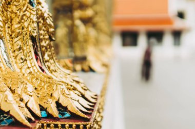 Budist tapınağındaki izole edilmiş duvarı olan arka plan Buddha 'nın kafa derisi yüzülüyor. Taylandlı yaşlı kadın iyi şanslar diliyor. Huzurlu ve kutsal meditasyon. Rahatla. Tayland tapınağındaki altın heykel