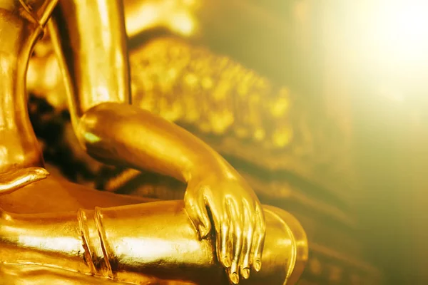 Background buddha face head body hands in buddhist temple with isolated wall. Thai old woman pray for good luck, zen peaceful and holy meditation relax. Gold statue in Thailand temple to worship