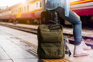 Solo sırt çantalı gezgin, Coronavirus krizinden sonra düşük maliyetli yaz tatili için güvenlik seyahati planlıyor. Tren istasyonunda boş bir turist. Sürdürülebilir çevre dostu ulaşım otobüsü kullan